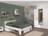 une chambre aux murs verts et au lit blanc
