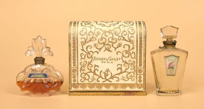 a small bottle of perfume next to a small bottle of perfume