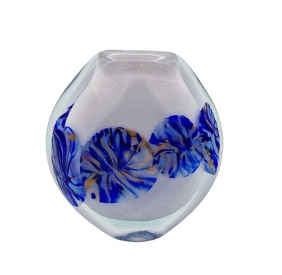 un vase en verre contenant des fleurs bleues et blanches