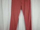 a pair of pink pants hanging on a hanger in front of a white curtain