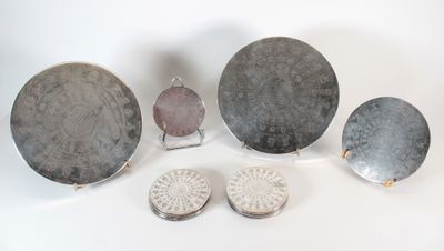 Plusieurs objets en argent sont disposés sur une surface blanche