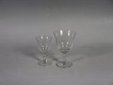 two empty wine glasses sitting on a white surface
