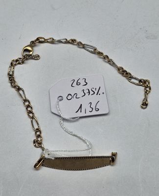 a close up of a gold chain bracelet with a tag on it