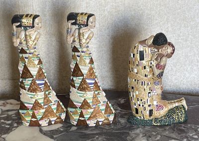 trois figurines représentant une femme et un homme, posées sur une table