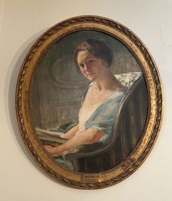 un tableau représentant une femme en train de lire un livre, accroché au mur