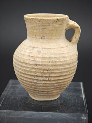 une image représentant un vase muni d'une anse, posé sur un socle