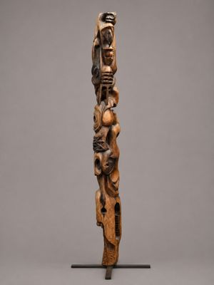 a wooden sculpture of a man holding a child on his back