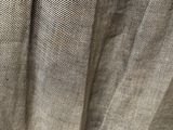the back of a beige shirt hanging on a hanger