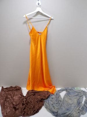 une robe suspendue à un cintre à côté d'une pile de vêtements