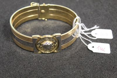 bracelet de couleur dorée, muni d'une boucle en métal et d'une étiquette
