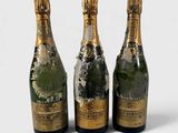 three bottles of champagne sitting next to each other on a white surface