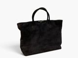 un sac fourre-tout en daim noir sur fond blanc