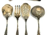 five spoons and a fork on a white surface