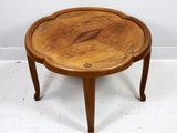 une petite table en bois avec un plateau en bois, posée sur un sol blanc