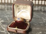 une bague dans une boîte posée sur une table, dans laquelle se trouve une bague