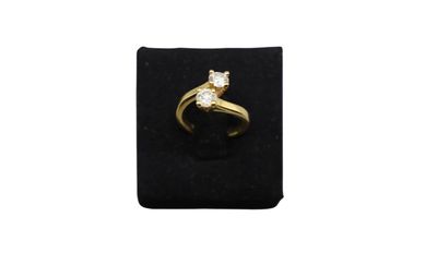a yellow gold ring with a diamond on a black velvet ring holder