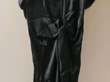 une photo d'une robe noire suspendue à un cintre accroché au mur