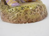 a figurine of a cat sitting on top of a rock