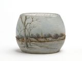 un petit vase avec un tableau posé sur une table
