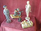 three figurines sitting on a table with a red cloth