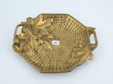 gold plate with leaves and leaves on it on a white surface