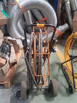 un petit chariot muni d'un tuyau, dans un entrepôt