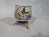 un petit vase avec un oiseau sur un support
