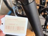 a person holding a bicycle that has a price tag attached to it
