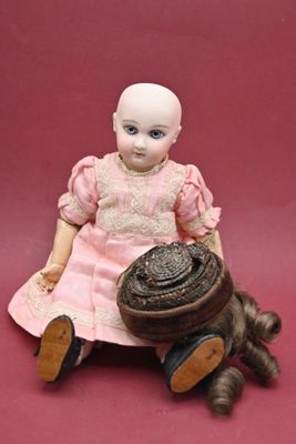 a doll that is sitting on the ground with a basket