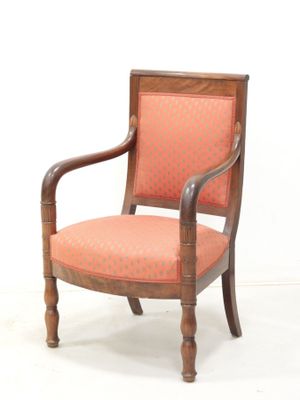 an old wooden chair with an orange upholstered seat