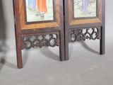 two wooden chairs with paintings on them in a room