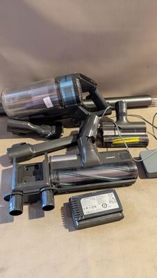 un aspirateur posé sur le sol à côté d'autres objets