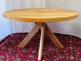 a wooden table with three wooden legs on a red carpet