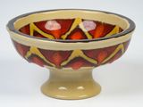 a red and yellow bowl sitting on top of a white table