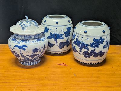 three blue and white vases sitting on a wooden table