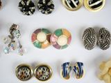 many different types of earrings and rings on the table