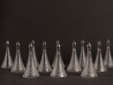 six cônes en verre transparent sont alignés sur un fond noir