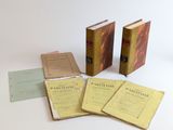 trois livres sont posés les uns à côté des autres sur une surface blanche