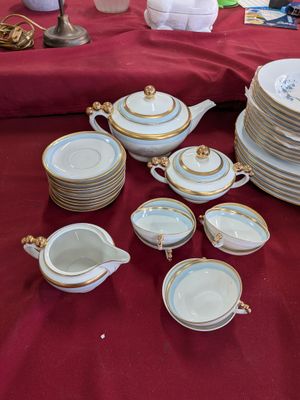 plusieurs assiettes et tasses sur une table avec une nappe rouge
