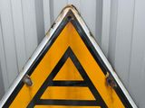 a yellow triangle sign with a black and white triangle on it