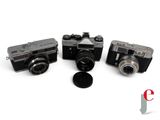 three cameras are sitting next to each other on a white surface