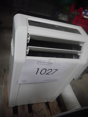 un climatiseur blanc posé sur une palette en bois