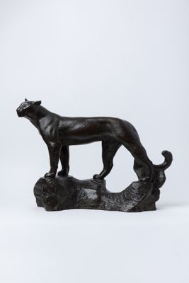statue d'un chien noir debout sur une bûche, sur fond blanc
