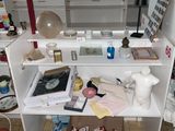 une étagère blanche sur laquelle sont posés divers objets, dans une pièce