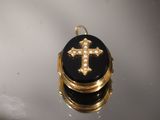 une image représentant un petit cadenas noir et doré orné d'une croix