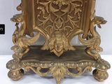 a gold clock sitting on top of a wooden table