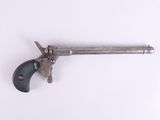 un vieux pistolet avec une poignée en bois sur une surface blanche
