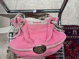 a pink purse sitting on top of a shopping cart