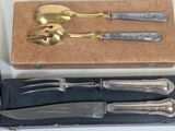 a box of silverware on a table next to a knife and fork