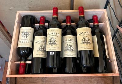 bouteilles de vin rouge dans un coffret en bois sur une table